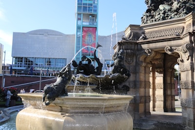 Elegant stone fountain displayed in a sunlit showroom.