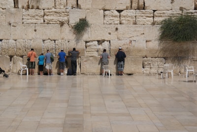 Pilgrims pausing in quiet reflection beside the ancient stone walls of the Tungnath temple.