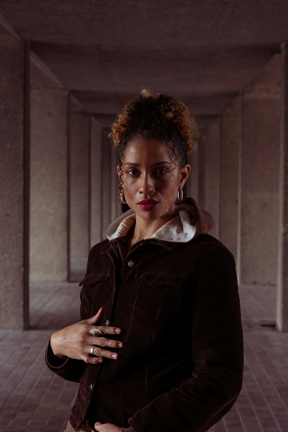 a woman standing in a hallway with her arms crossed