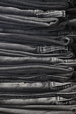 Stacks of denim fabric rolls ready for export in a clean warehouse.