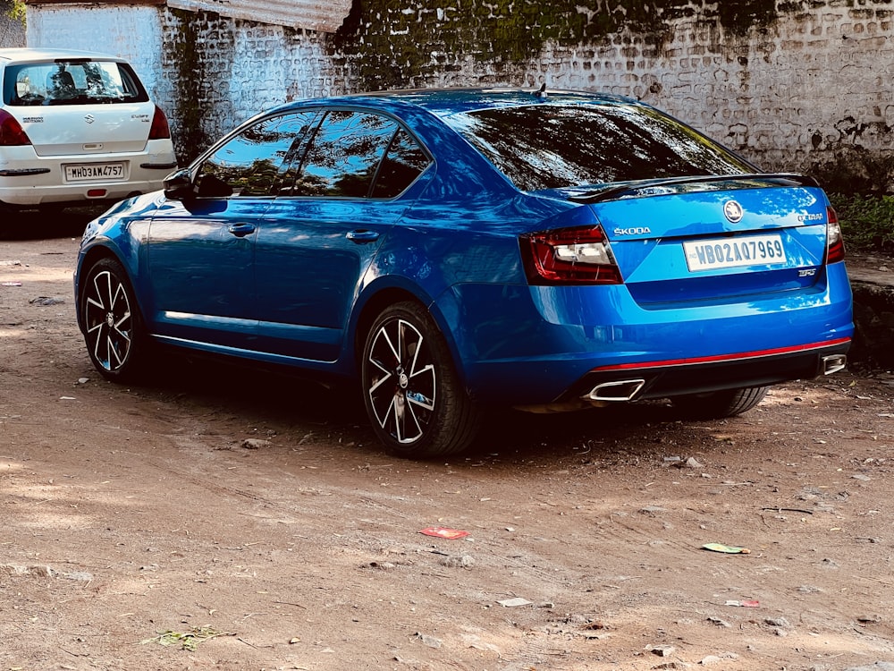 a blue car parked on a dirt road