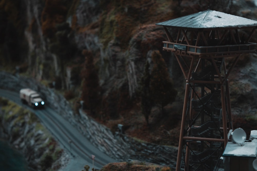 a car driving down a road next to a tall tower