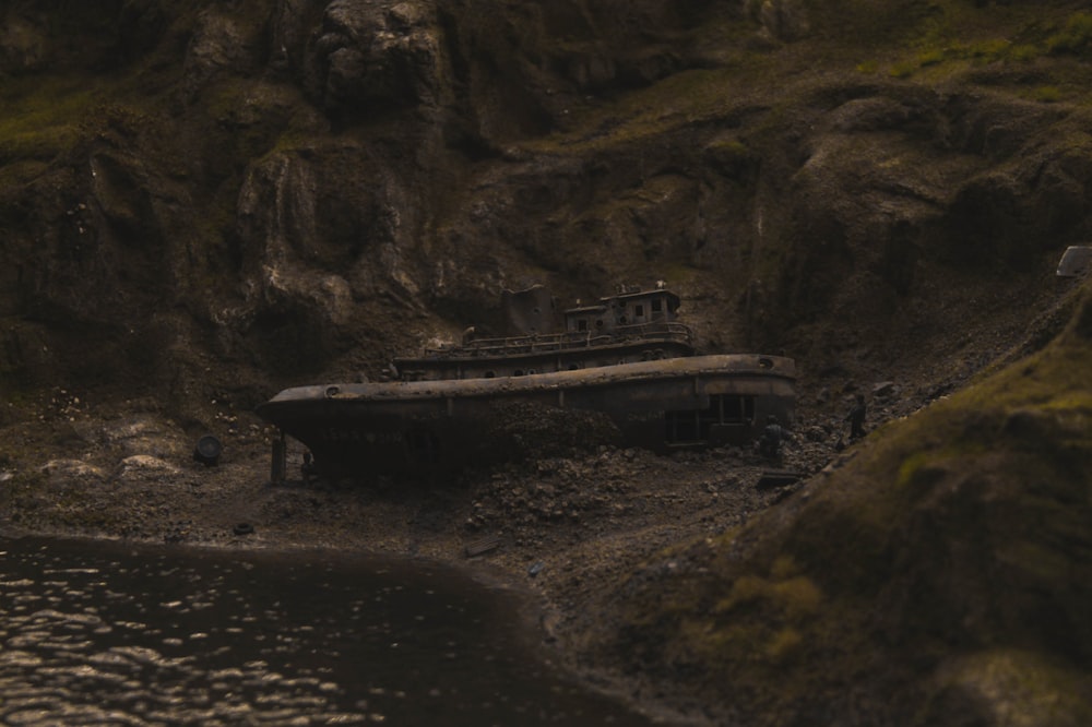 an old boat sitting on the shore of a body of water