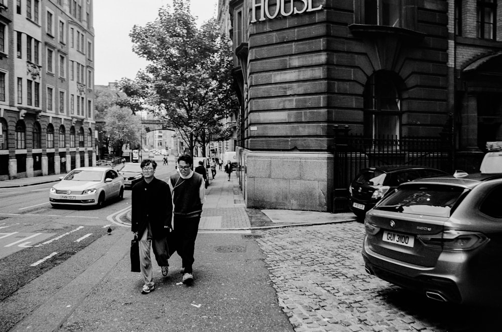 a couple of people walking down a street next to a tall building