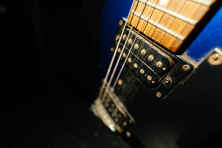 Close-up of a deep blue sea-themed electric guitar resting on a noir background.