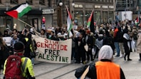 a group of people walking down a street holding flags