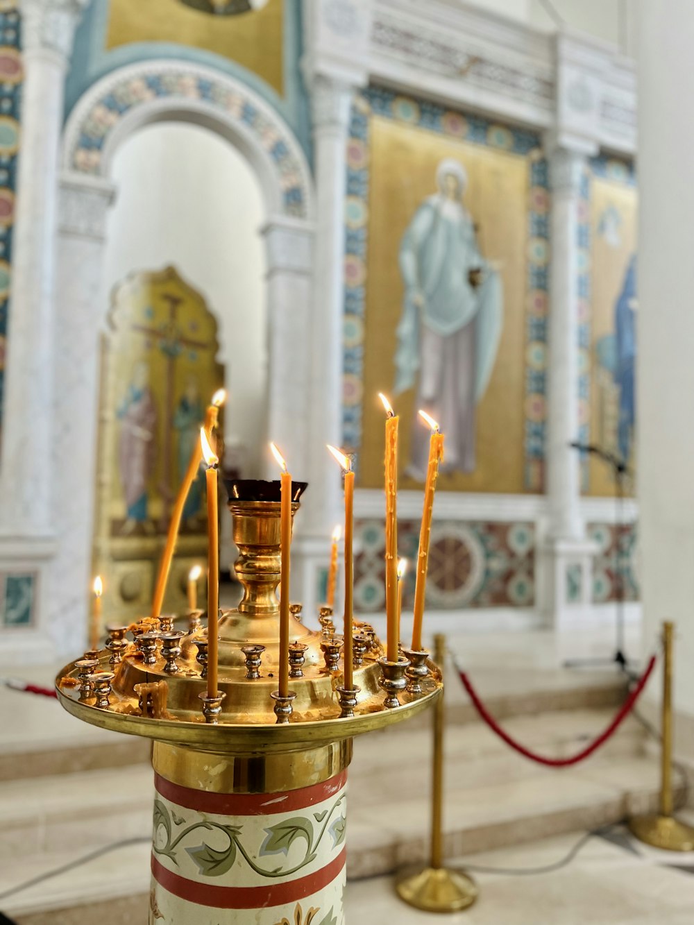 a candle holder with many lit candles in a church