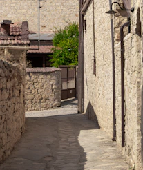 an alley way with a clock on the side of it