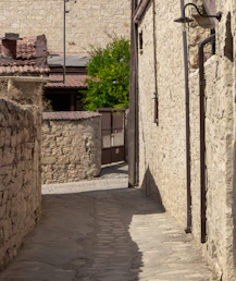 an alley way with a clock on the side of it