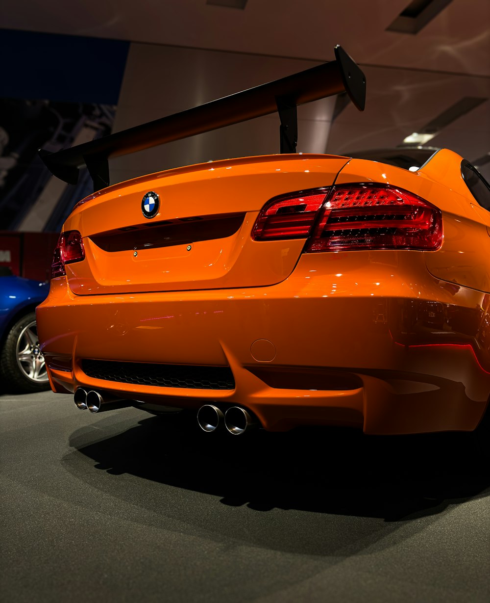 an orange sports car parked in a showroom