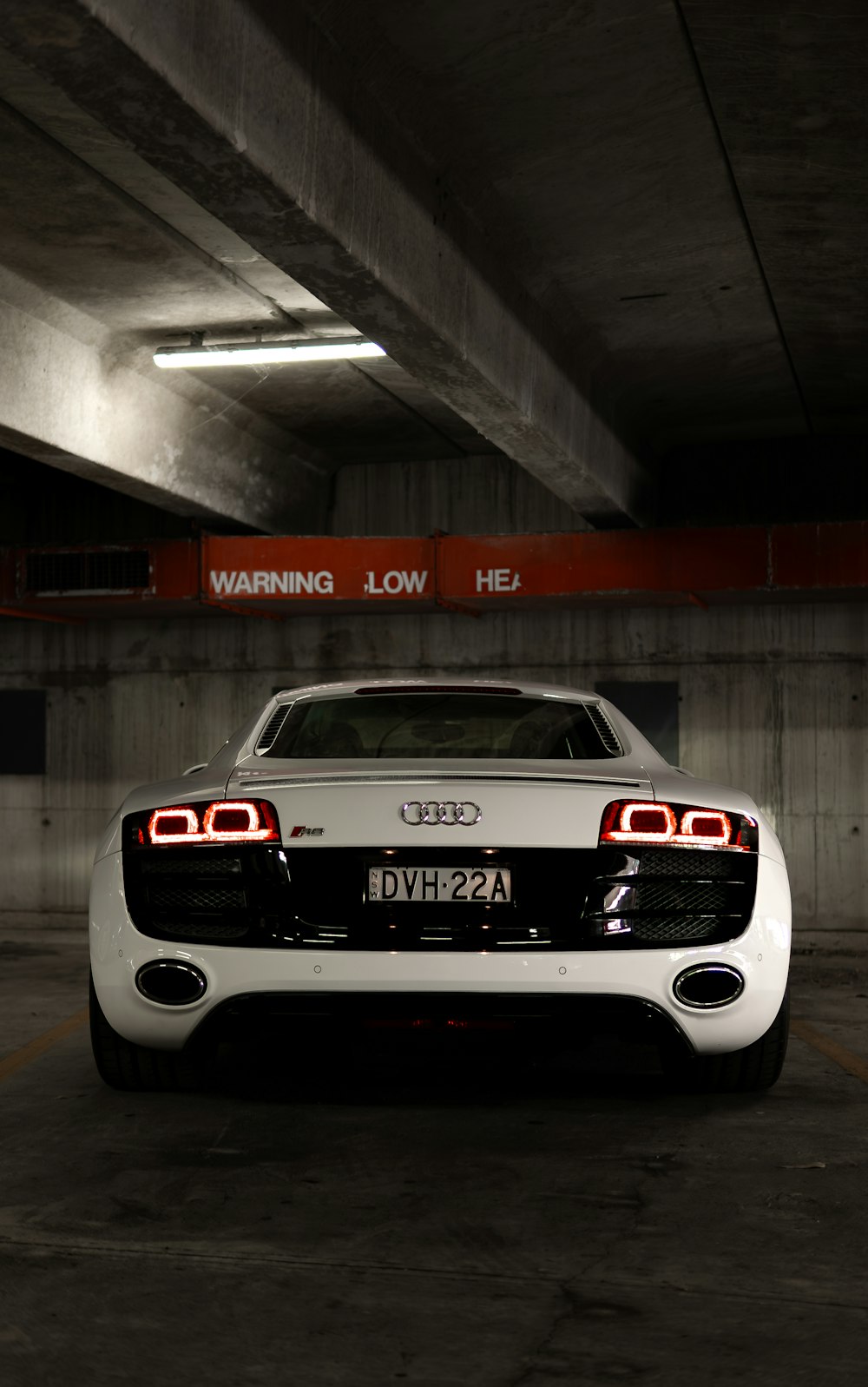 a white sports car parked in a parking garage