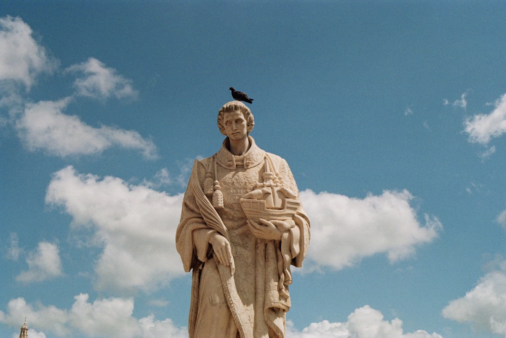 une statue d’homme avec un oiseau sur la tête