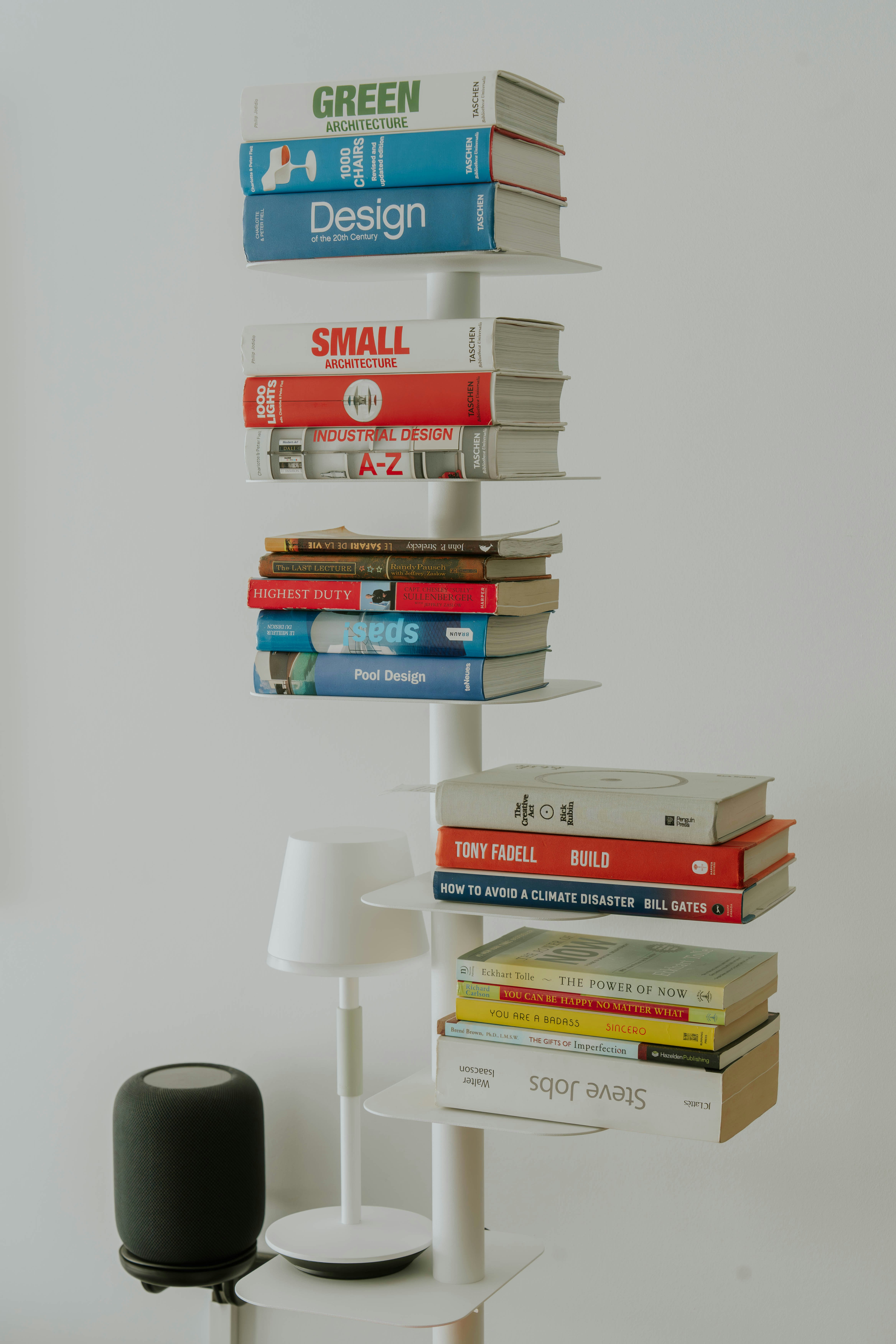 a stack of books sitting on top of a white shelf