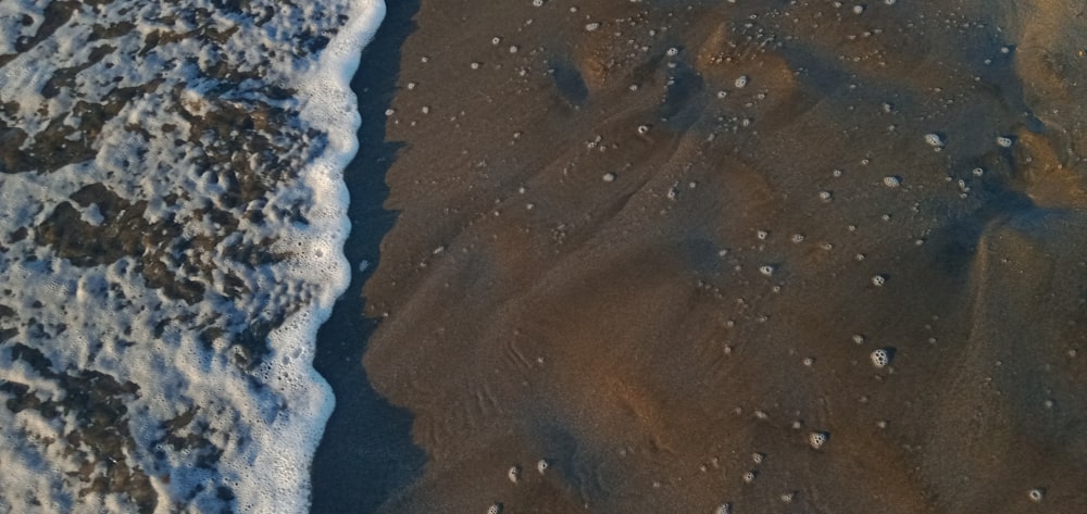 Una veduta aerea di una spiaggia con onde e sabbia