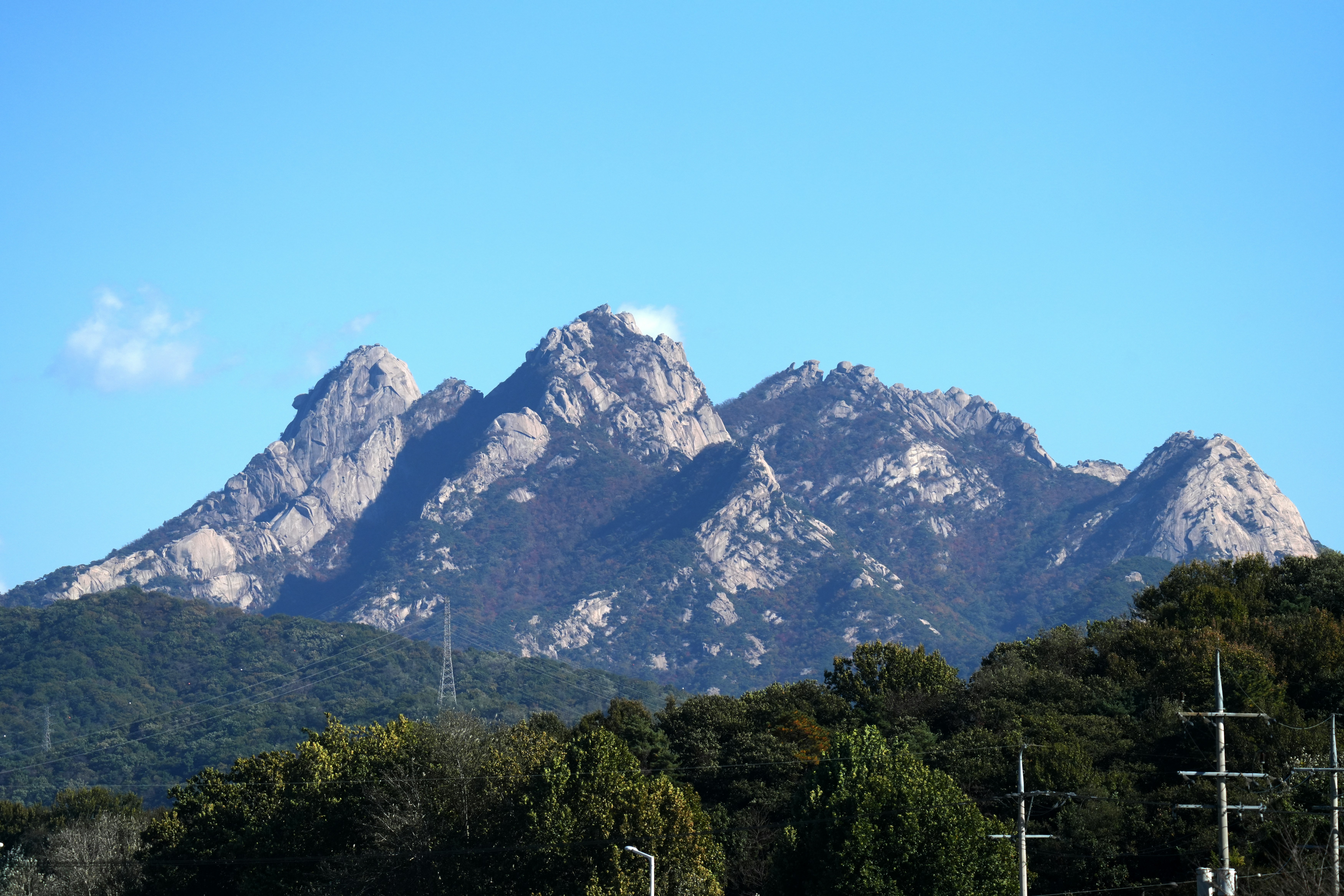 a mountain range with telephone poles in the foreground