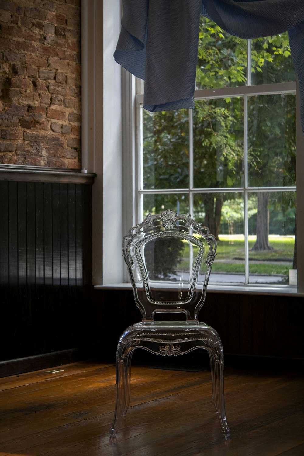 a clear chair sitting in front of a window