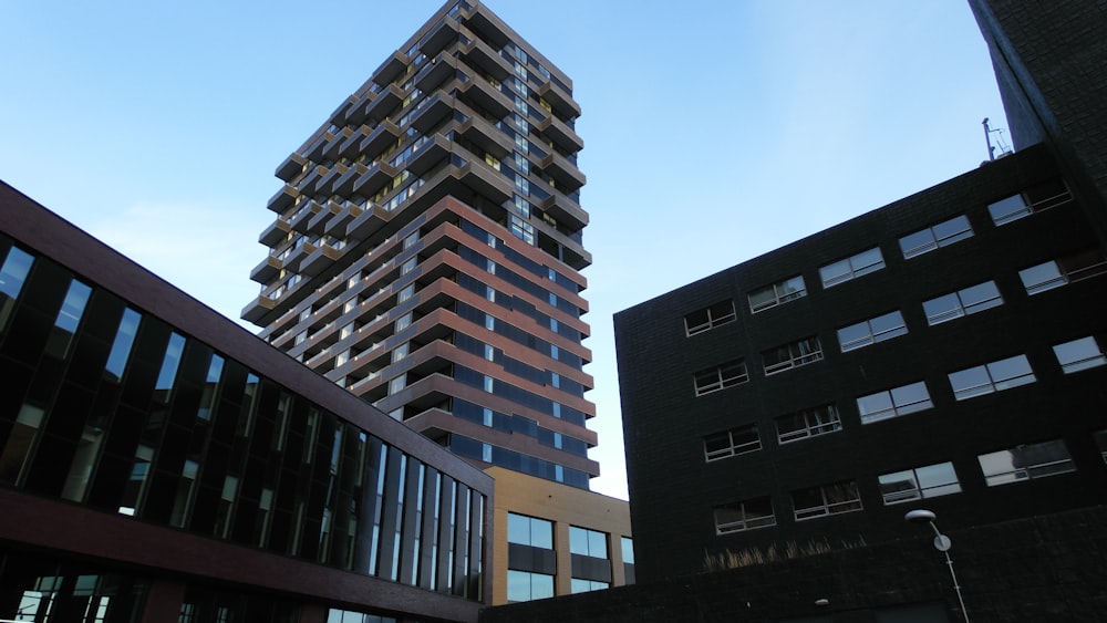 a tall building towering over a city next to other buildings