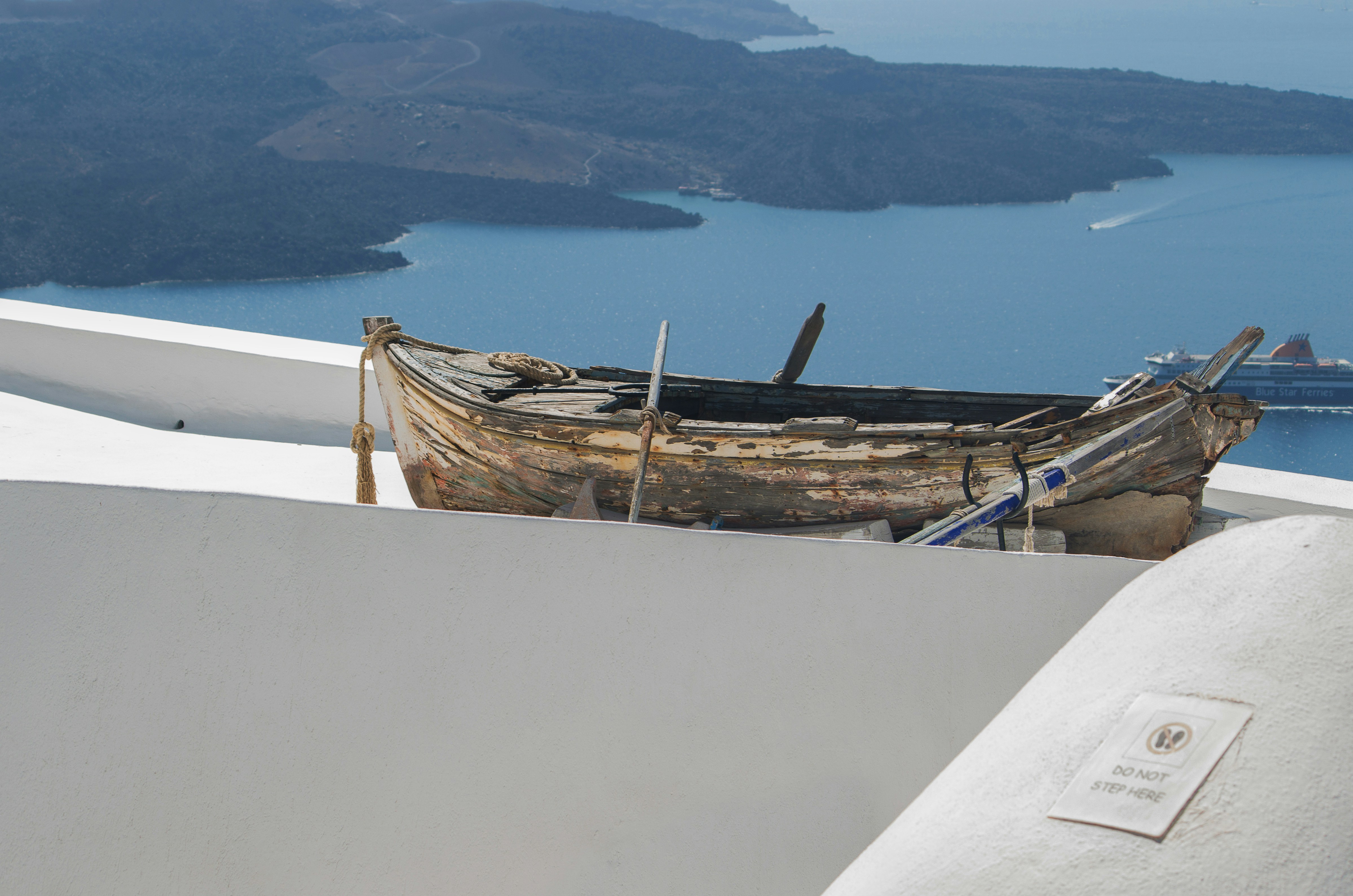 a boat sitting on top of a roof next to a body of water