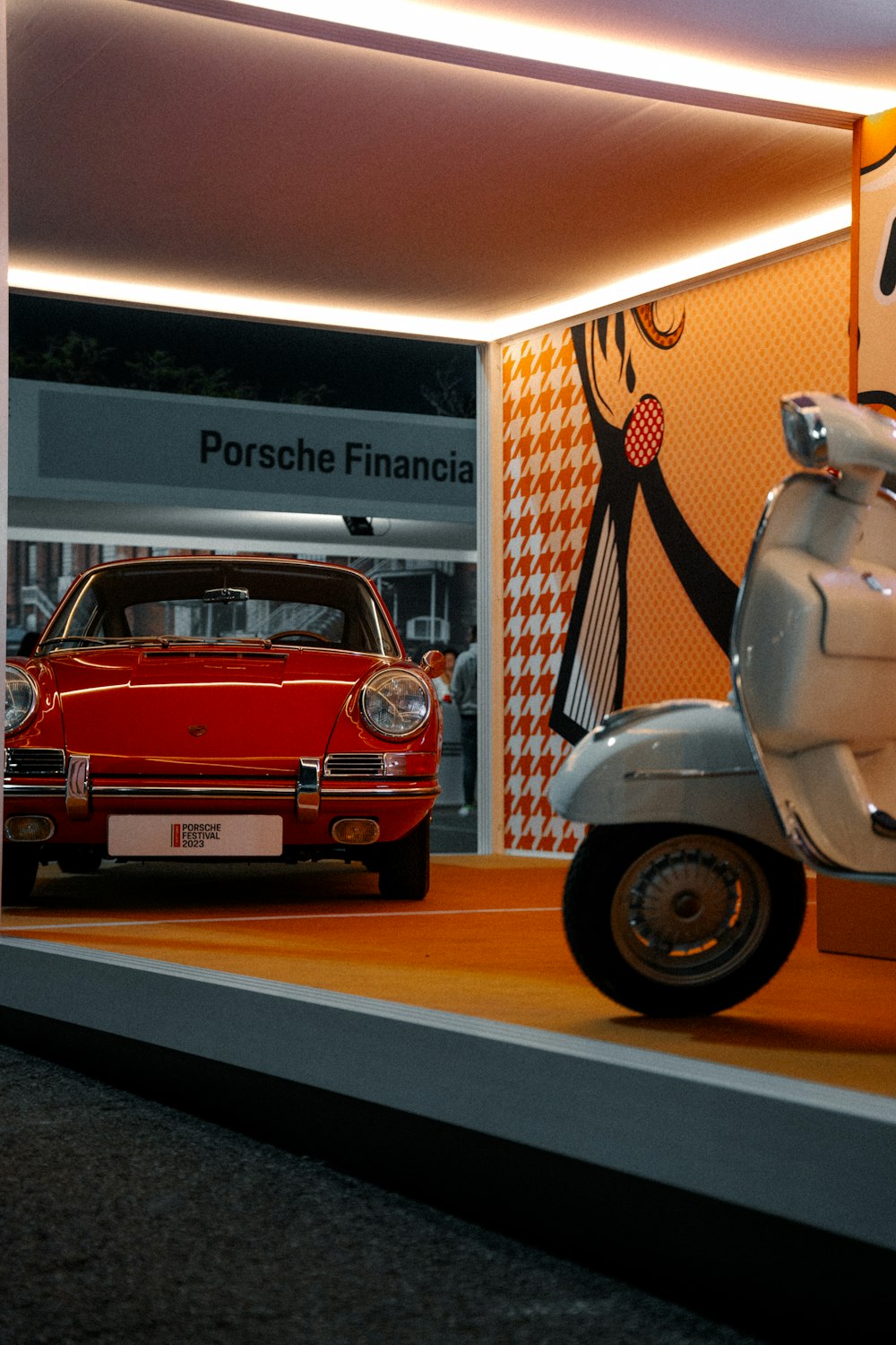 a scooter and a car on display in a museum