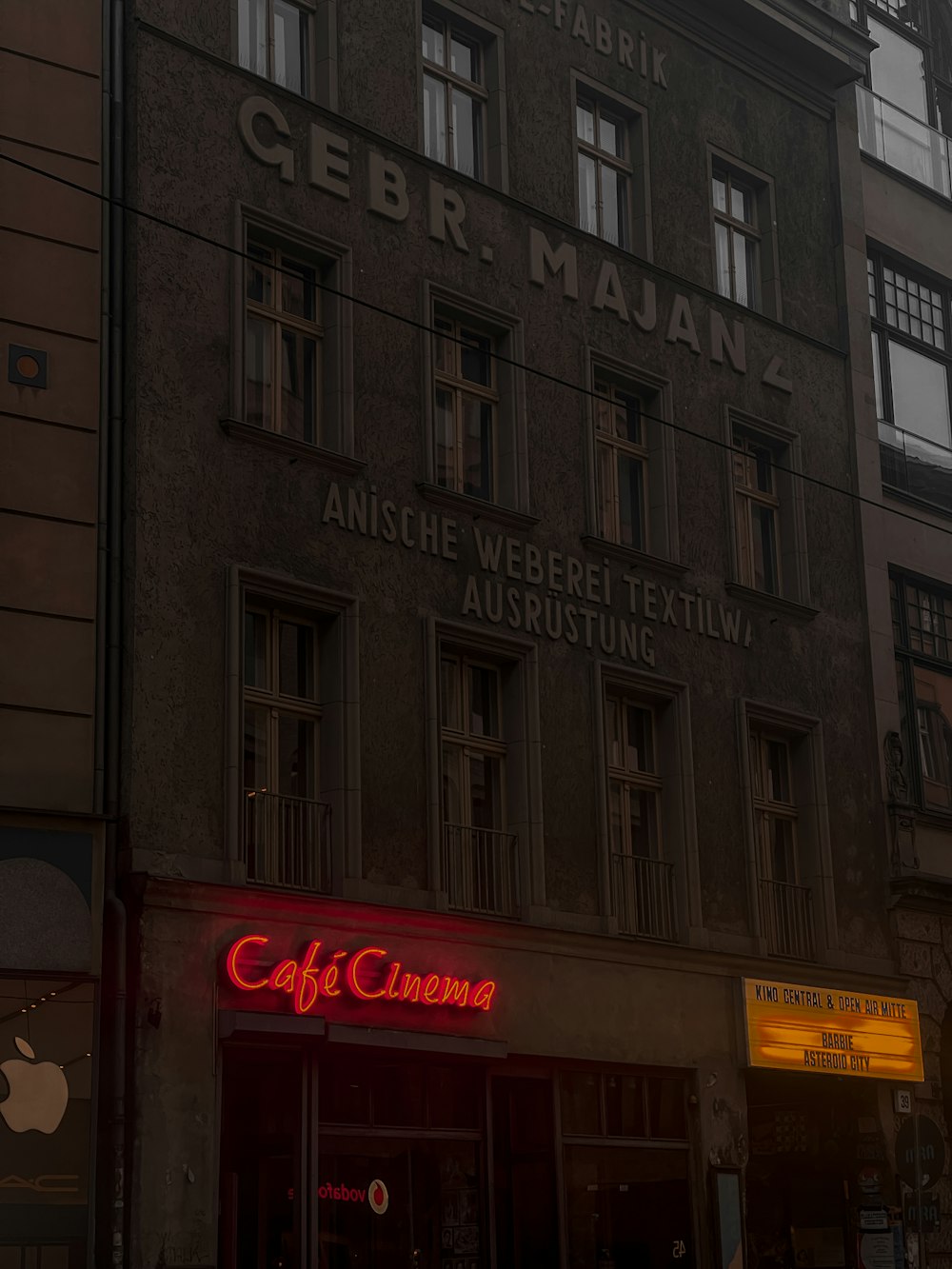 an old building with a neon sign in front of it