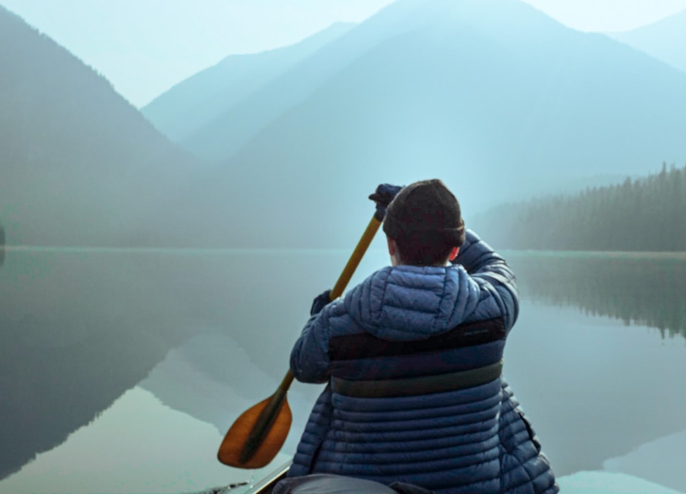 un uomo sta pagaiando su una canoa su un lago