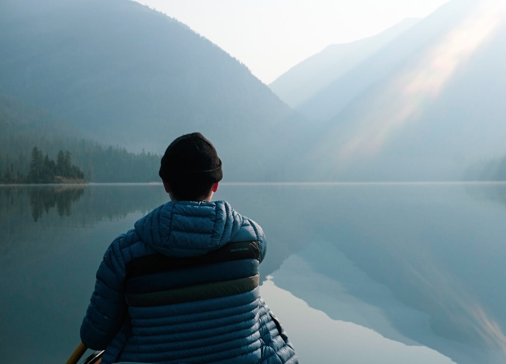 a person sitting on a boat looking out over a lake