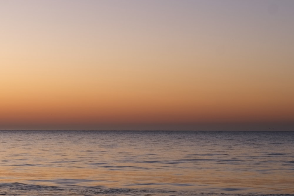 a boat in the water at sunset with a sky background