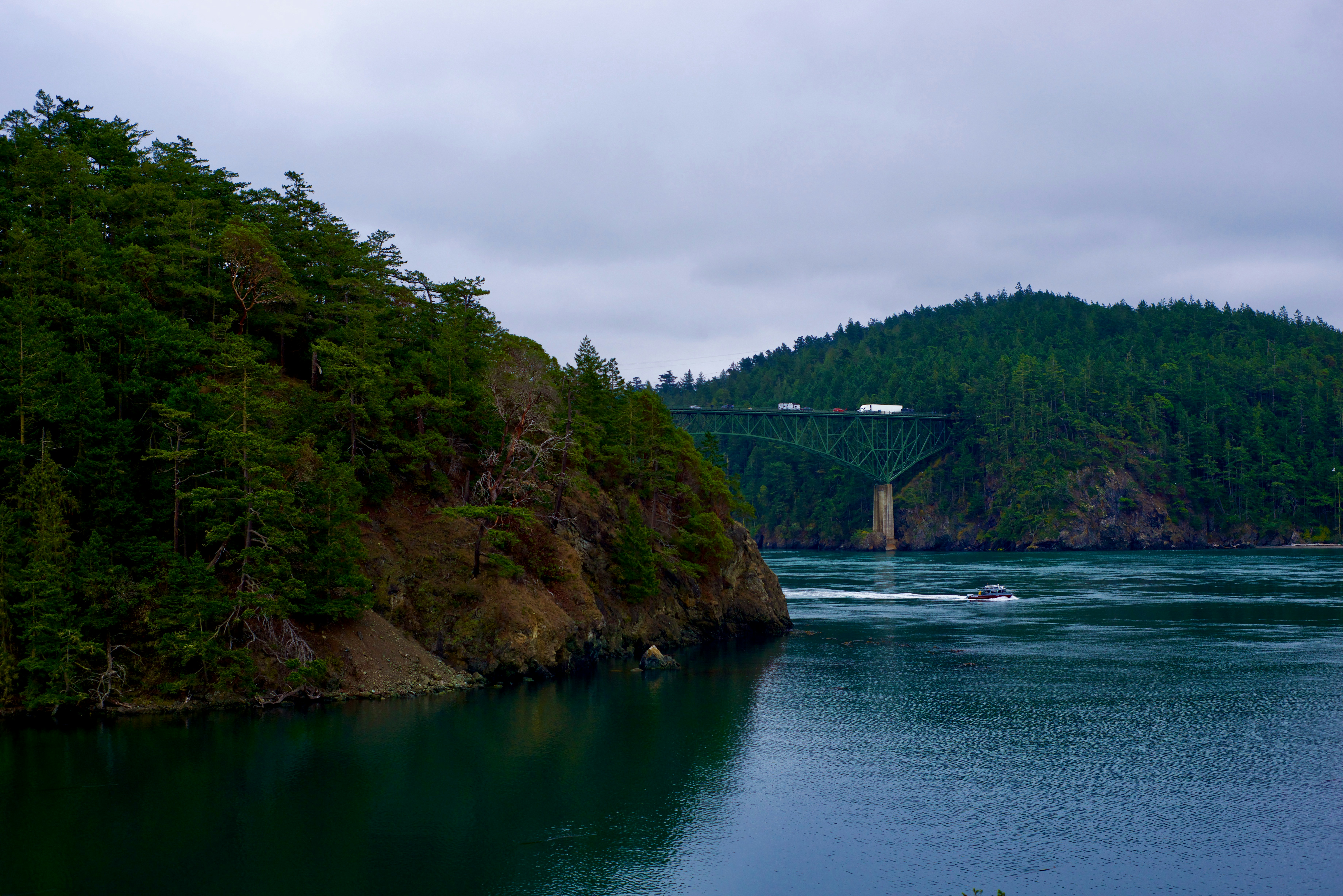 a boat is going under a bridge on the water