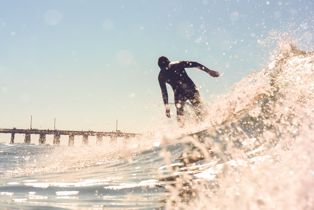 a man riding a wave on top of a surfboard