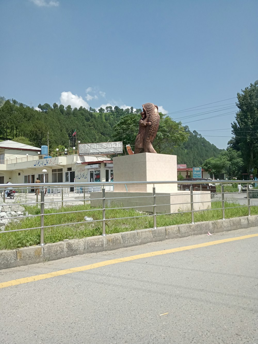 a large statue of a bear on the side of a road