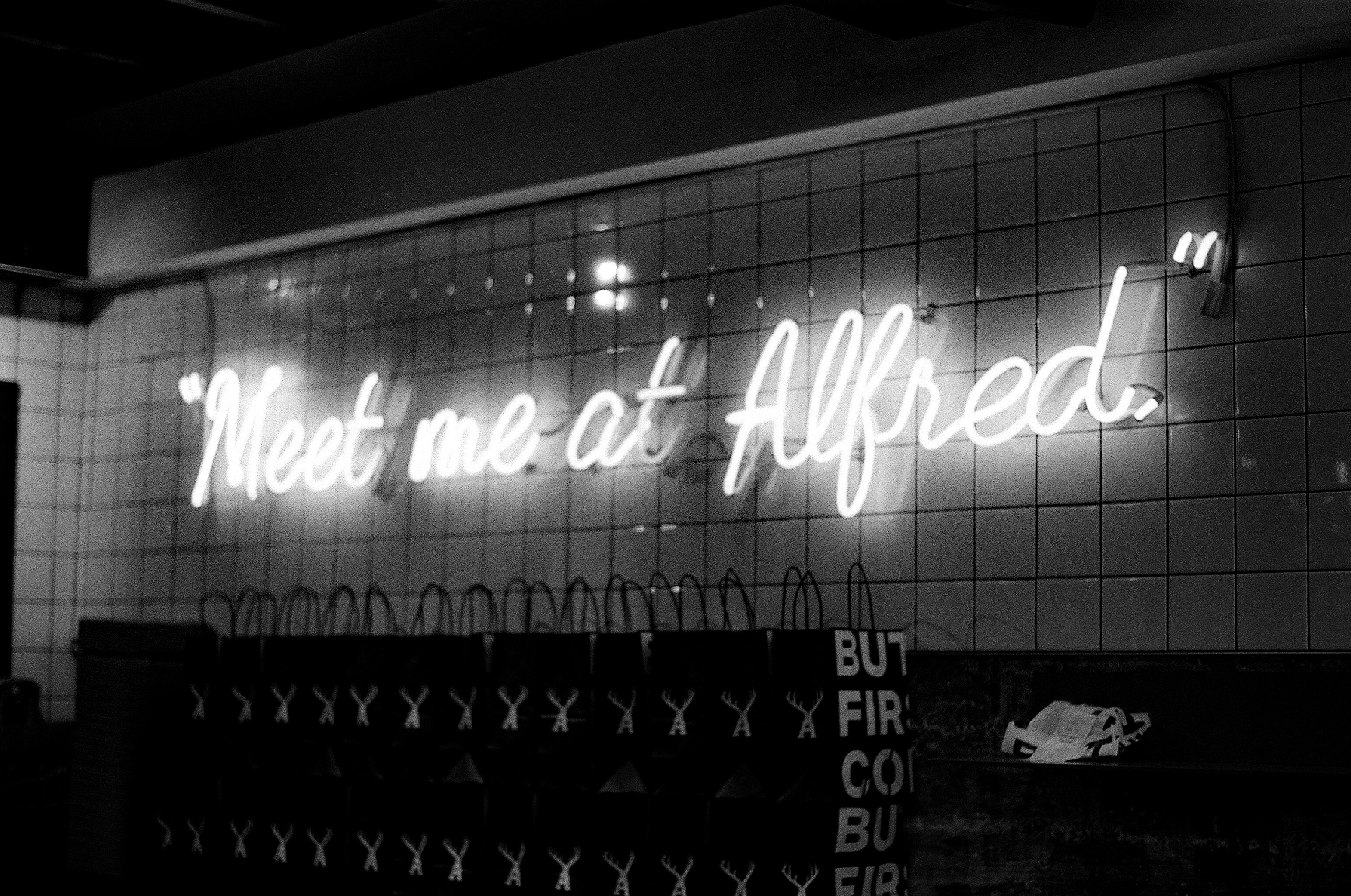 Enseigne néon lumineuse sur une façade de briques dans un quartier branché