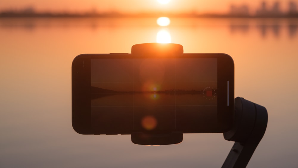 Un primer plano de una cámara con una puesta de sol en el fondo
