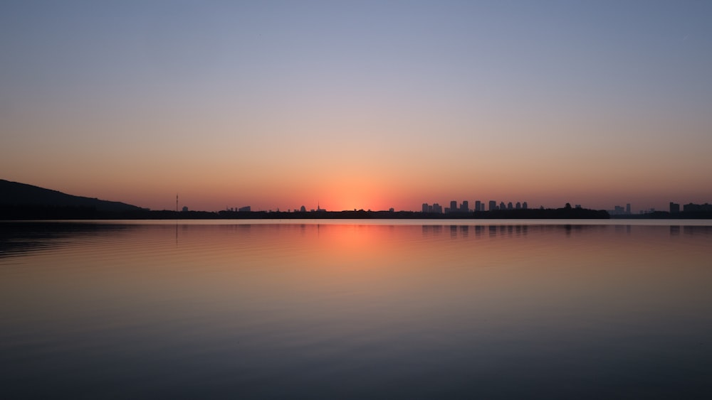 the sun is setting over a body of water