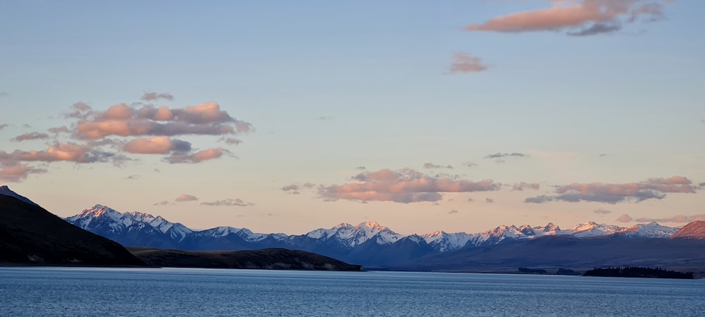 a large body of water with mountains in the background