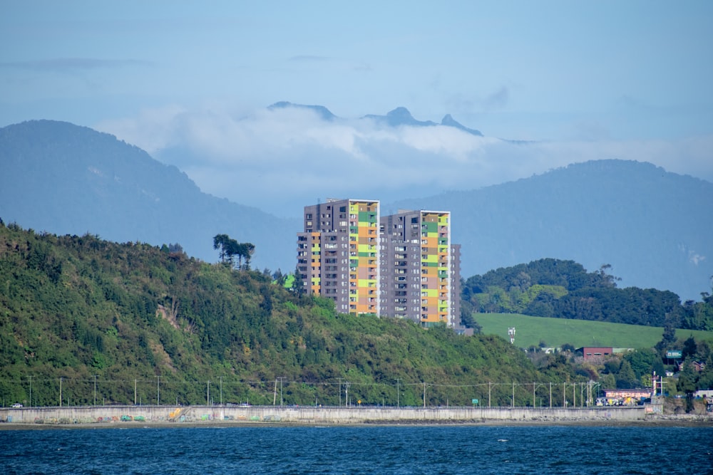 a tall building sitting on top of a lush green hillside