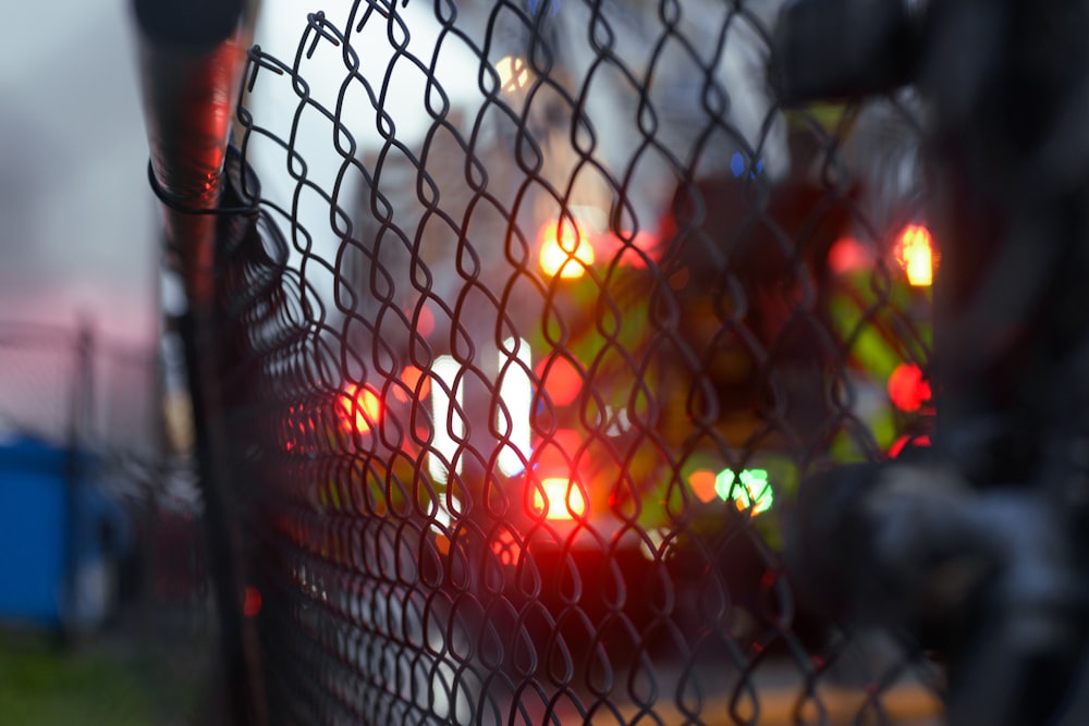 a close up of a traffic light through a mesh fence