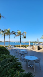 Guests enjoying a brunch party on a spacious waterfront lawn under blue skies.