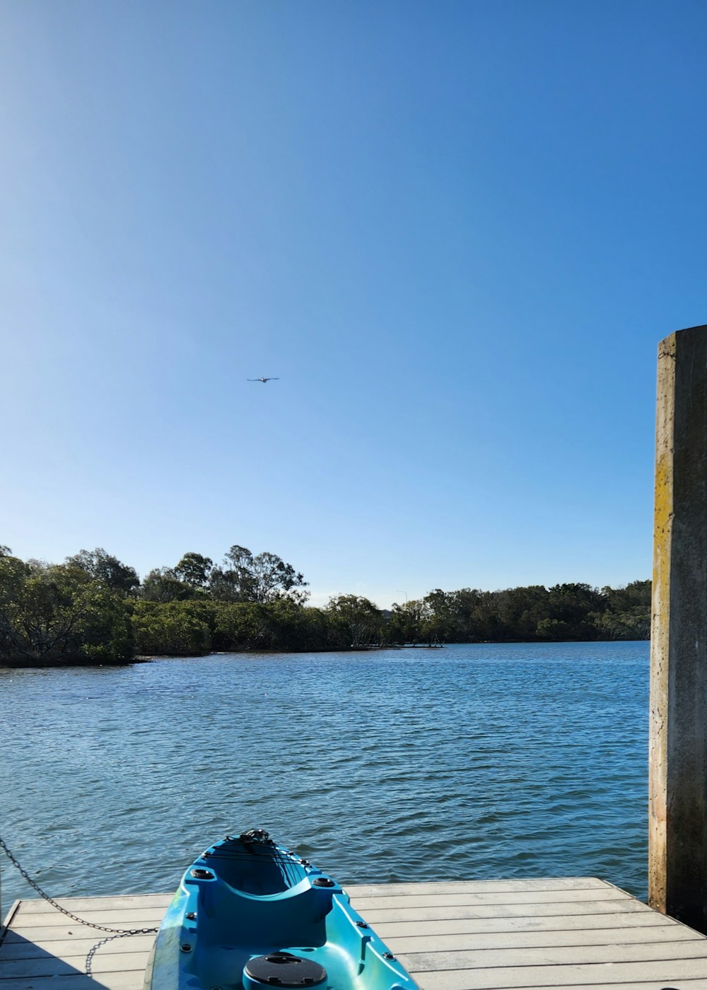 a blue kayak sitting on a dock next to a body of water