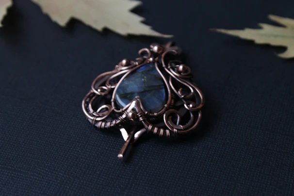 A beautifully designed gold pendant with a subtle blue gemstone centerpiece, reflecting the brand’s colors.