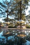 a pool with umbrellas and lounge chairs next to it