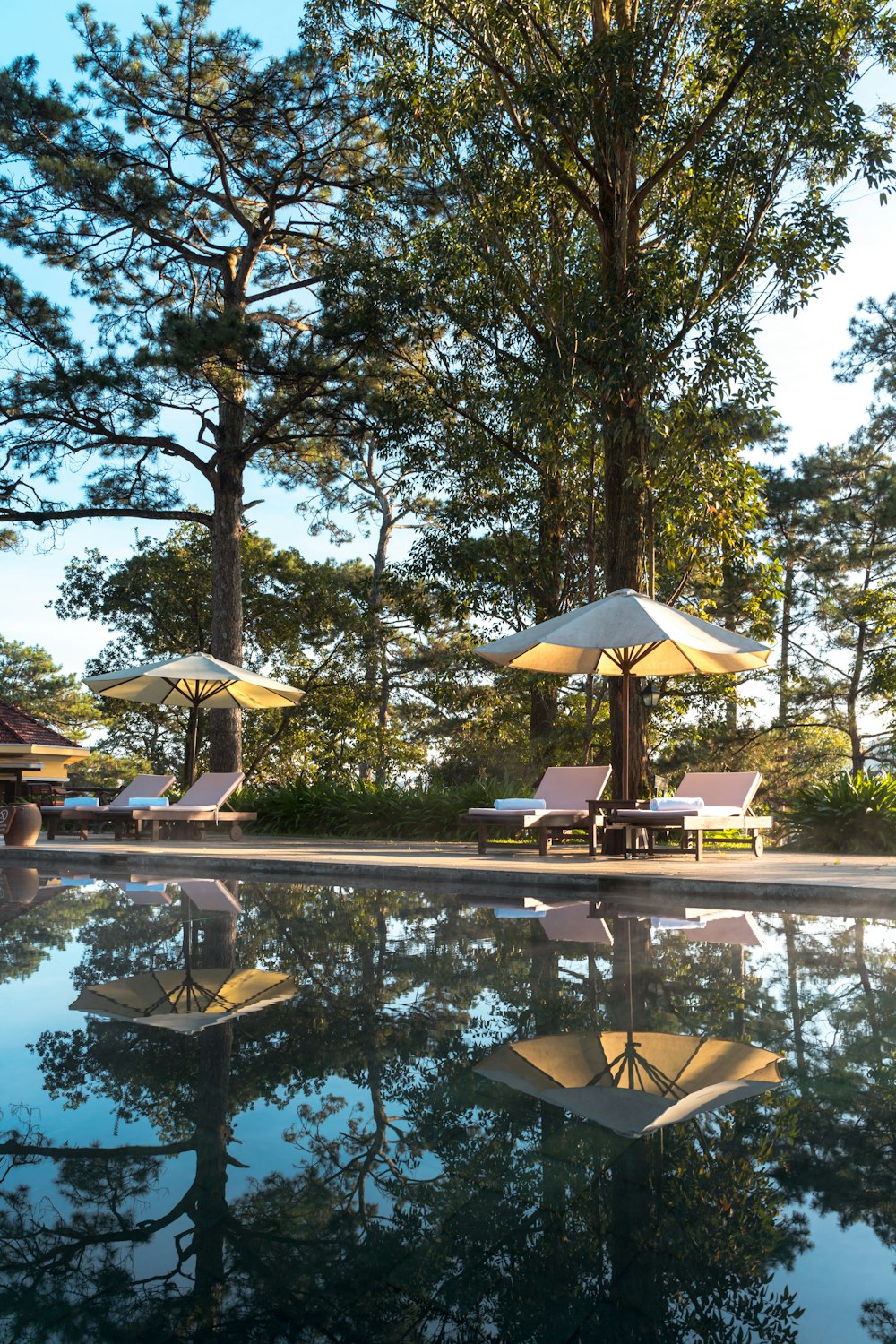 a pool with umbrellas and lounge chairs next to it