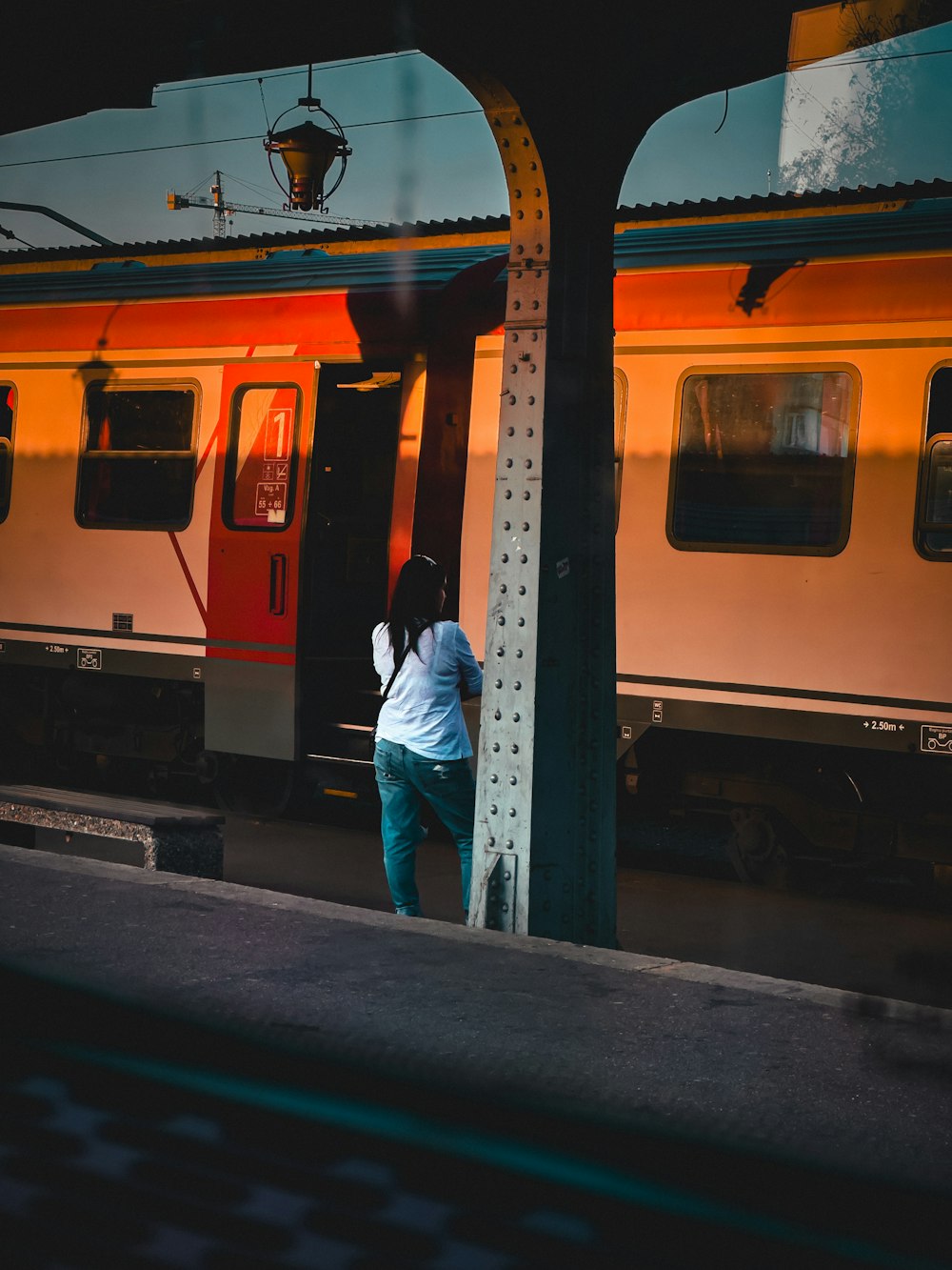 eine Person, die auf einem Bahnsteig neben einem Zug steht