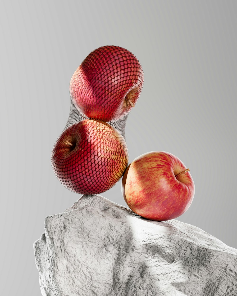 a couple of apples sitting on top of a rock