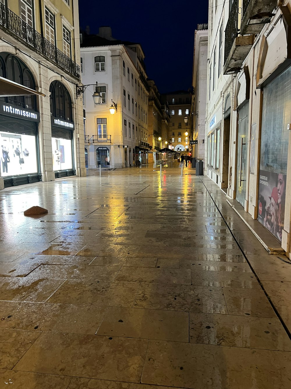a wet sidewalk in a city at night