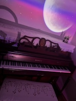 An elegant upright piano with a lace cover is placed in a room with a surreal projection of a large moon on the wall. The colors of the projection cast a soft pink and purple glow over the scene, and a small vase with plants is situated on top of the piano.