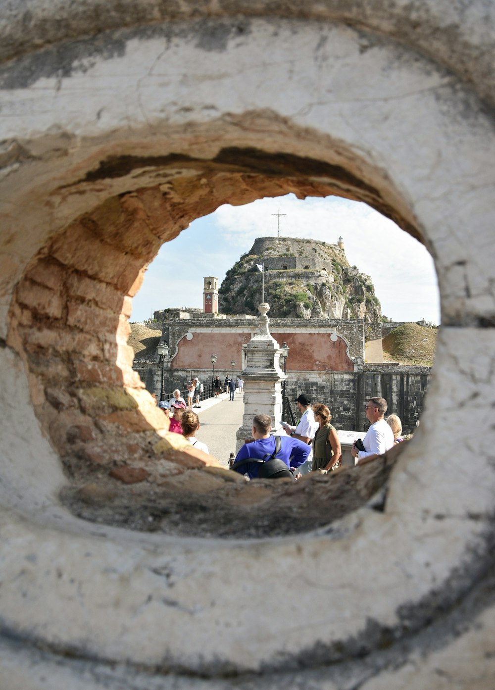 a group of people sitting on top of a stone wall