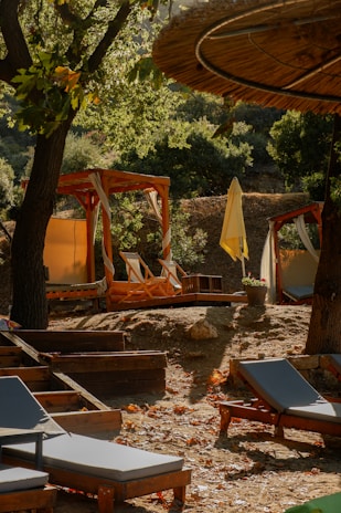Elegant outdoor lounge setup with sleek sunbeds and umbrellas under soft natural light.