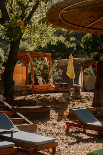 Elegant outdoor lounge setup with sleek sunbeds and umbrellas under soft natural light.