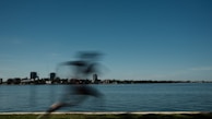A dynamic shot of a runner in Lumina Apparel activewear sprinting along a city waterfront.
