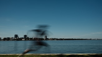 A dynamic shot of a runner in Lumina Apparel activewear sprinting along a city waterfront.